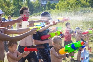 Children playing outdoors with water cannons on a beautiful sunny day. Water battle, water game battle. High quality photo